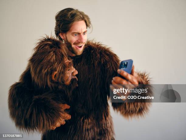man playing online poker on a smartphone - gorilla suit stock pictures, royalty-free photos & images