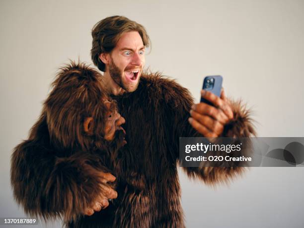 man playing online poker on a smartphone - gorilla suit stock pictures, royalty-free photos & images