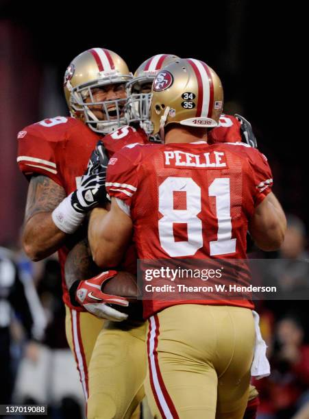 Vernon Davis of the San Francisco 49ers celebrates with teammates after catching a 14 yard touchdown pass in the fourth quarter against the New...