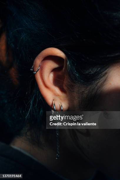 closeup ear piercings on woman's ear - hoop earring fotografías e imágenes de stock