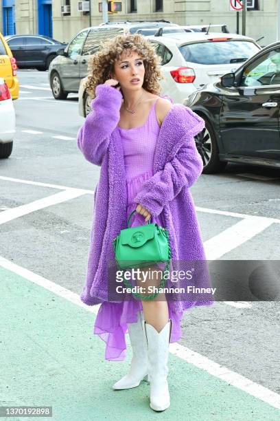 Guest wears white Western-inspired boots with a bright purple gingham handkerchief and a teddy coat in the same hue at Spring Studios during New York...