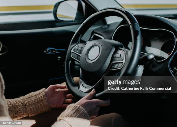 female hands holding steering wheel in a car - steering wheel stock-fotos und bilder