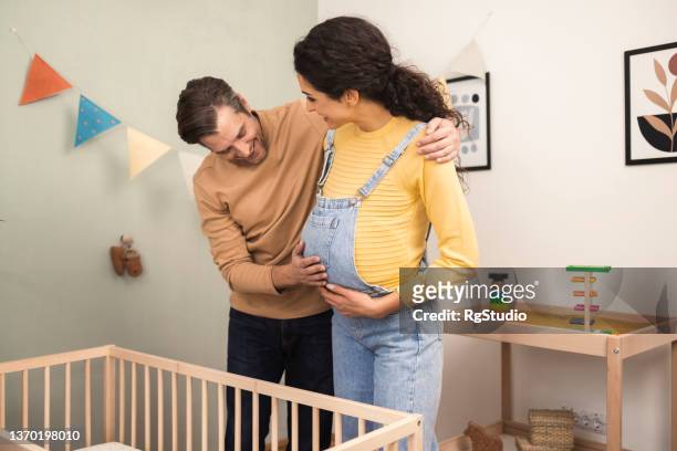 portrait of a happy couple enjoying while waiting for the baby - couples studio portrait stock pictures, royalty-free photos & images