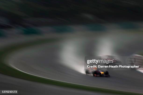 In back lit light, and wet and rain conditions German Red Bull Racing Formula One team racing driver Sebastian Vettel driving his RB9 racing car at...