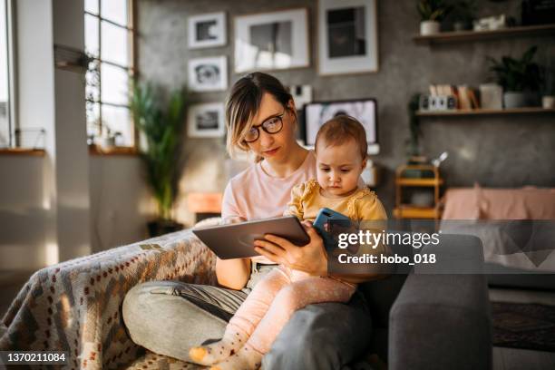 mother and baby daughter online shopping. - simple living stock pictures, royalty-free photos & images