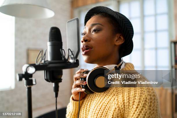 woman singing into a large microphone - música soul imagens e fotografias de stock