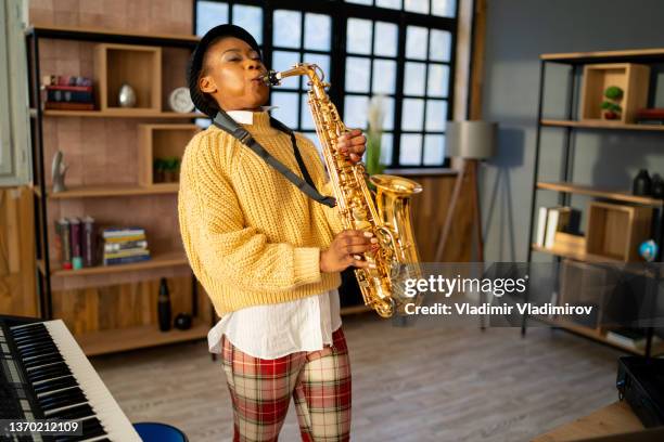 a saxophonist playing a saxophone in a music studio - sax stockfoto's en -beelden