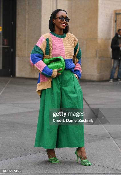 Guest is seen wearing a Victor Glemaud sweater and green pants outside the Victor Glemaud show during New York Fashion Week A/W 2022 on February 12,...