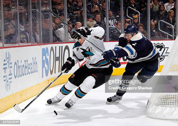 Andrew Murray of the San Jose Sharks tries to get control of the puck in front of Aaron Johnson of the Columbus Blue Jackets at Nationwide Arena on...