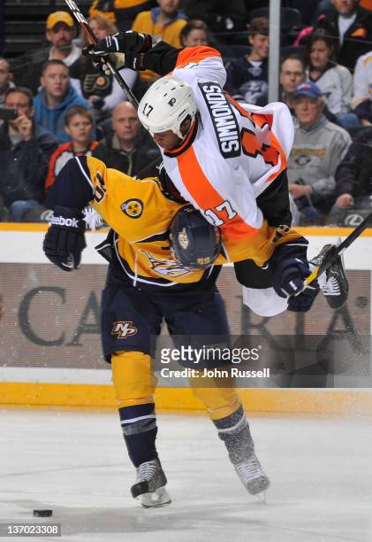 Ryan Ellis of the Nashville Predators checks Wayne Simmonds the Philadelphia Flyers off the puck during an NHL game at the Bridgestone Arena on...