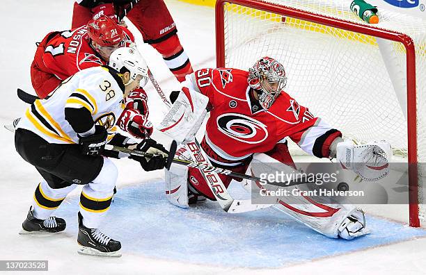 Goalkeeper Cam Ward of the Carolina Hurricanes stops a point-blank shot by Jordan Caron of the Boston Bruins during the third period at the RBC...