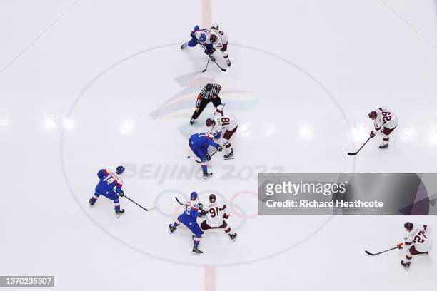 Rodrigo Abols of Team Latvia and Marek Hrivik of Team Slovakia take the center ice opening face-off in the first period of the Men's Ice Hockey...