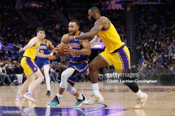 Stephen Curry of the Golden State Warriors drives to the basket against LeBron James of the Los Angeles Lakers in the second half at Chase Center on...