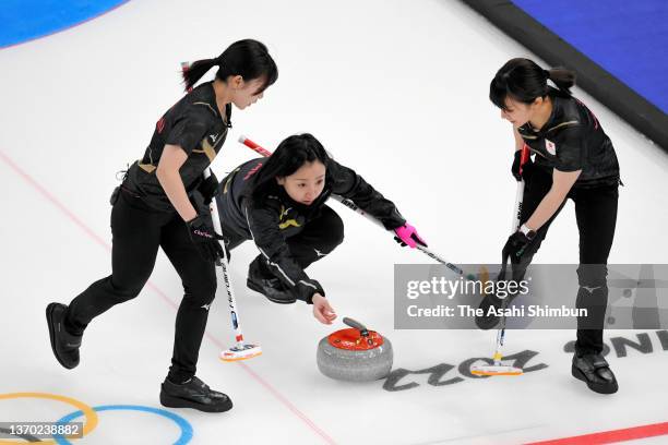 Satsuki Fujisawa of Team Japan delivers the stone while Yurika Yoshida and Yumi Suzuki sweep in the 10th end during the Curling Women's Round Robin...