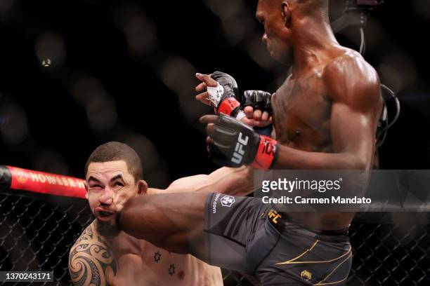 Israel Adesanya of Nigeria kicks Robert Whittaker of Australia in their middleweight championship fight during UFC 271 at Toyota Center on February...