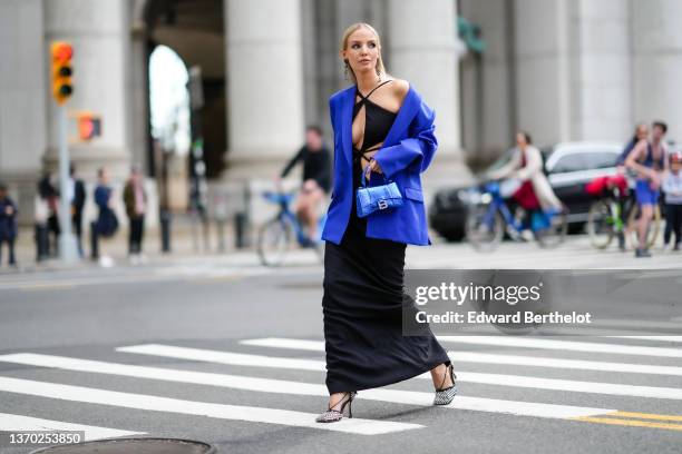 Leonie Hanne wears black rhinestones heart pendant earrings from YSL / Saint Laurent Paris, black rhinestones vintage sunglasses, a black V-neck /...