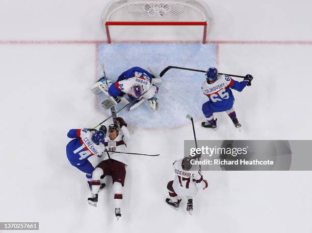 Goaltender Patrik Rybar of Team Slovakia gets defensive help from Peter Ceresnak and Michal Cajkovsky in the crease area during the second period...