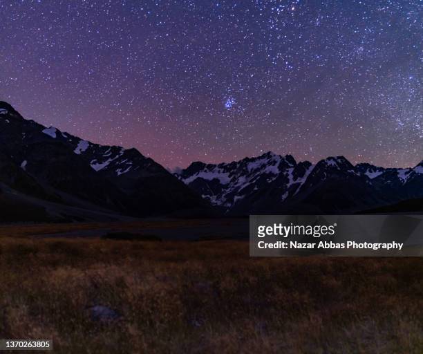 night sky with snow peaks in the background. - lake tekapo new zealand stock pictures, royalty-free photos & images