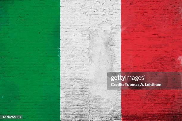 full frame photo of a weathered flag of italy painted on a plastered brick wall. - italy flag stock pictures, royalty-free photos & images