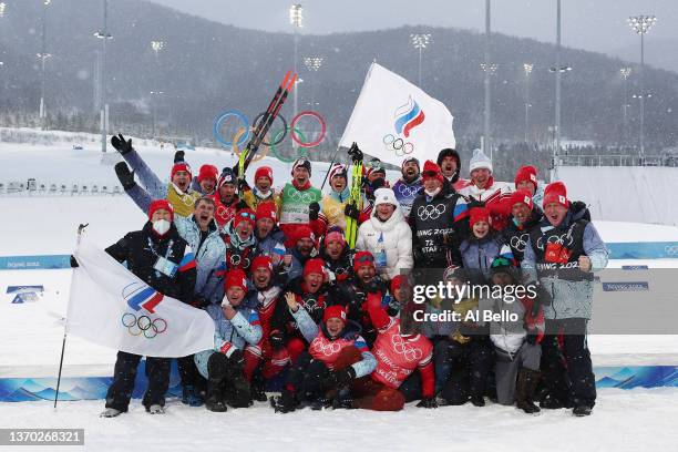 Gold medallists Alexey Chervotkin, Alexander Bolshunov, Denis Spitsov and Sergey Ustiugov of Team ROC celebrate with their team and staff during the...