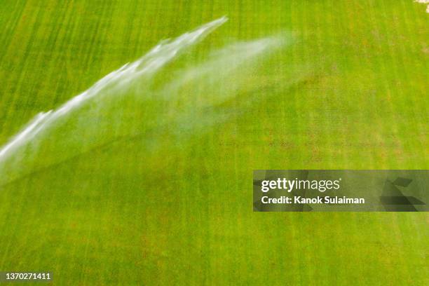 water irrigation system spraying on green field - sprinkler system ストックフォトと画像