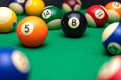 BILLIARD BALLS ON A POOL TABLE. THE EIGHT BLACK ONE IN FOCUS. LEISURE CONCEPT.