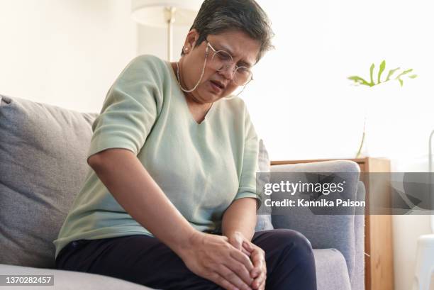 senior asian woman suffering from knee pain. - human joint stock pictures, royalty-free photos & images