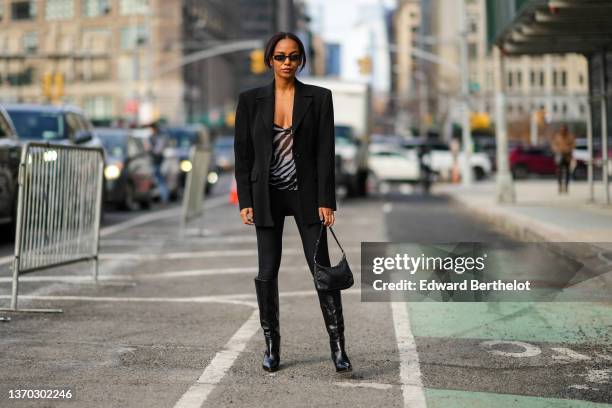 Guest wears black sunglasses, a black and gray zebra print pattern V-neck t-shirt, a black blazer jacket, black legging pants, a black embossed LV...