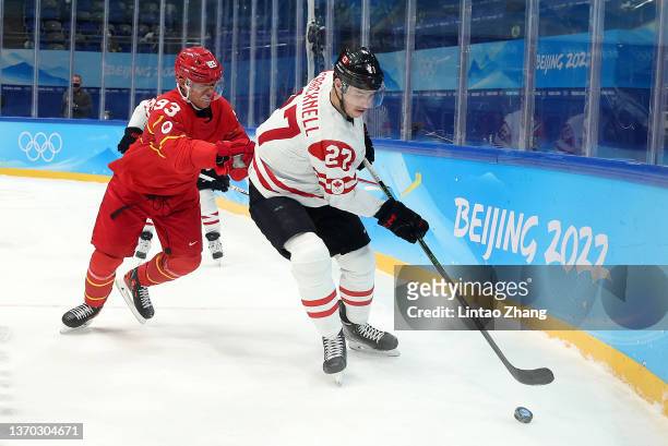 Junjie Yuan of Team China and Adam Cracknell of Team Canada challenge for the puck during the Men's Ice Hockey Preliminary Round Group A match...