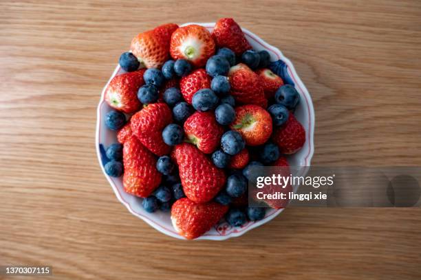 blueberries and strawberries on the plate - summer fruits stock pictures, royalty-free photos & images