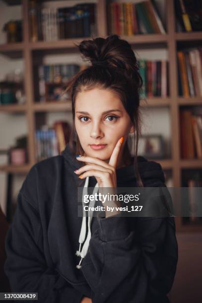 portrait of a teenage girl (14-15 years) in front of a bookcase - 14 15 years girls stockfoto's en -beelden