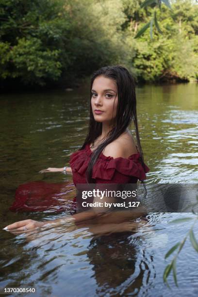 portrait of a teenage girl in a river - girls in wet dresses stock-fotos und bilder