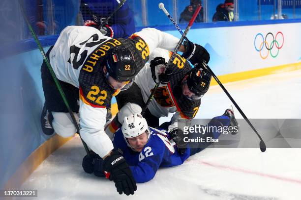 Matthias Plachta of Team Germany and Dominik Kahun of Team Germany challenge Aaron Ness of Team United States during the Men's Ice Hockey Preliminary...