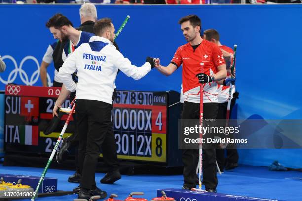 Joel Retornaz of Team Italy interacts with Peter De Cruz of Team Switzerland following their sides victory during the Men's Curling Round Robin...