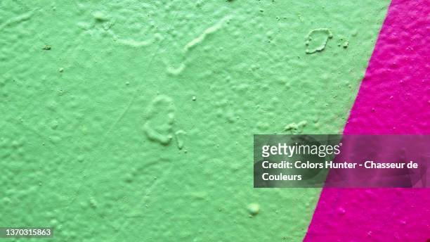 light green and bright pink paintings on a textured concrete wall in paris - hunter green 個照片及圖片檔