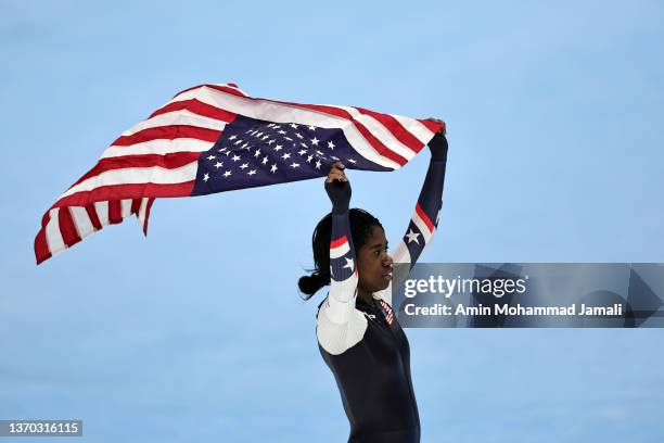 Erin Jackson of Team United States skates with the American flag after winning the Gold medal during the Women's 500m on day nine of the Beijing 2022...