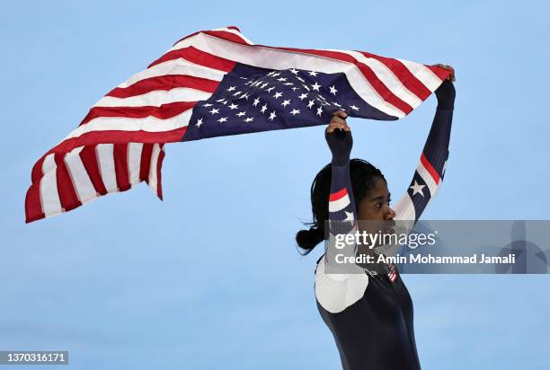 Erin Jackson of Team United States skates with the American flag after winning the Gold medal during the Women's 500m on day nine of the Beijing 2022...