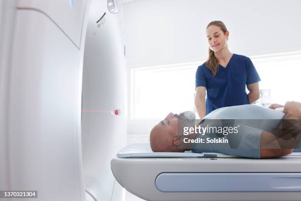 medical professional helping mature man in ct scanner - tomography 個照片及圖片檔