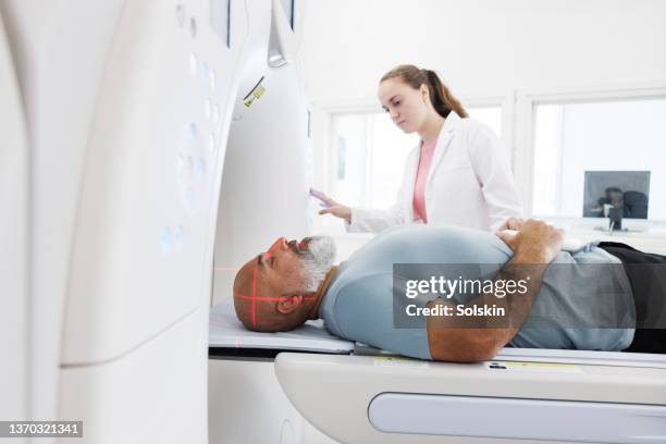 radiographer helping patient in ct scanner - cancer bildbanksfoton och bilder