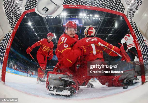 Taile Wang and Yongli Ouban of Team China fail to stop the score by Eric O'Dell of Team Canada during the Men's Ice Hockey Preliminary Round Group A...