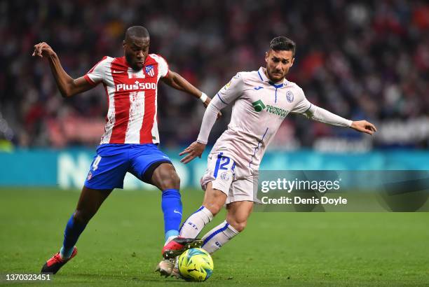 Oscar Rodriguez of Getafe CF is tackled by Geoffrey Kondogbia of Atletico de Madrid during the LaLiga Santander match between Club Atletico de Madrid...