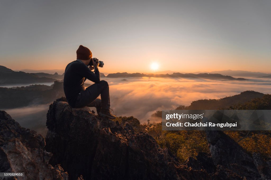 Tourist enjoys sunset with camera at Phu Pha Mok view point at Baan Ja Bo in Mae Hong Son province, Thailand.