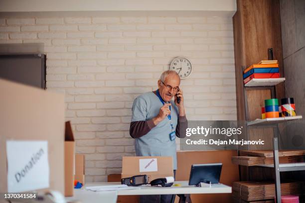 old man on using mobile phone - charity benefit stock pictures, royalty-free photos & images