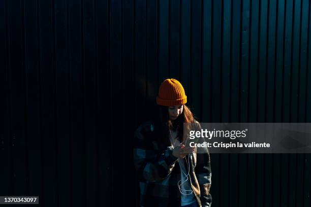 waist-up shot of a teenage girl in a plaid jacket using her cell phone - spain teen face bildbanksfoton och bilder