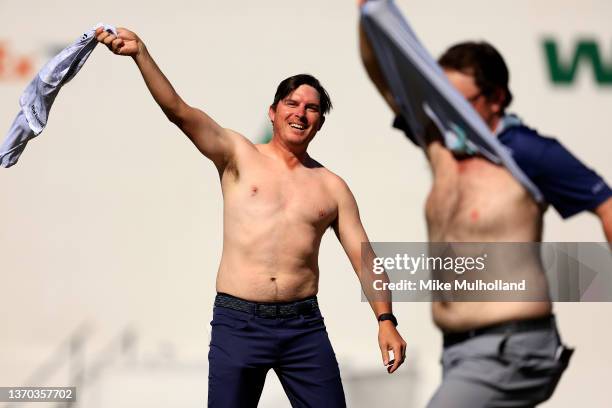 Joel Dahmen and Harry Higgs of the United States take their shirts off on the 16th hole during the final round of the WM Phoenix Open at TPC...