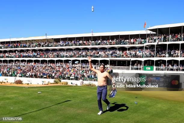 Joel Dahmen of the United States tosses a beer in the air with his shirt off on the 16th hole during the final round of the WM Phoenix Open at TPC...