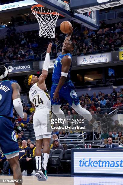 Anthony Edwards of the Minnesota Timberwolves dunks the ball over Buddy Hield of the Indiana Pacers in the second quarter at Gainbridge Fieldhouse on...
