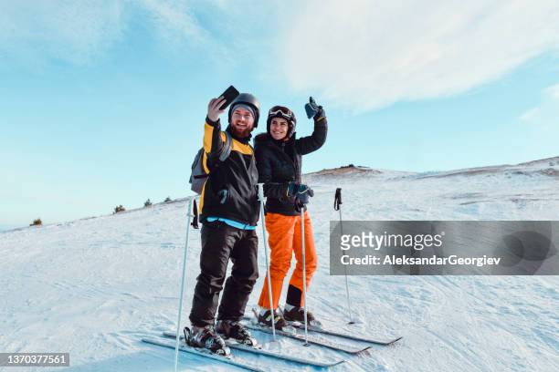 cute skiing couple and their selfie while enjoying snowy mountain fun - couple ski lift stockfoto's en -beelden