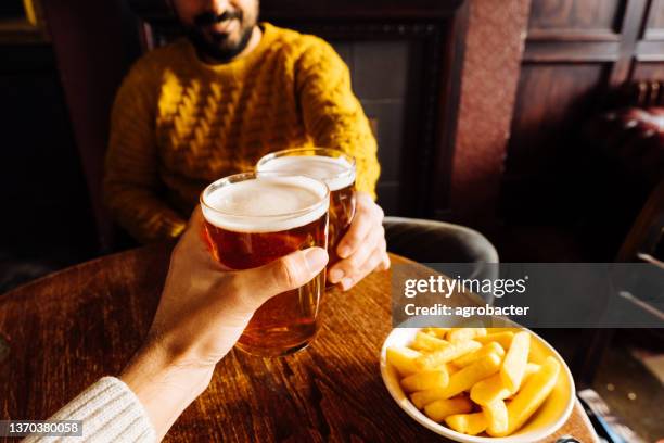 cheers! clink glasses. close-up shots of hands holding beer glasses and beer bubbles - ale stock pictures, royalty-free photos & images