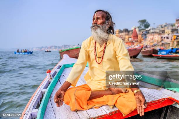 sadhu is meditating in boat on holy ganges river, varanasi - varanasi stock pictures, royalty-free photos & images